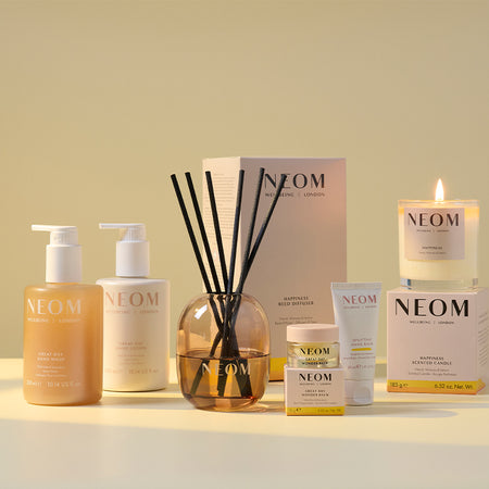NEOM product line-up including hand wash and lotion, reed diffuser, wonder balm, hand balm and a candle on a light background