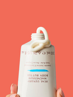 NEOM Real Luxury magnesium body butter cream squeezed from tube showing rich texture