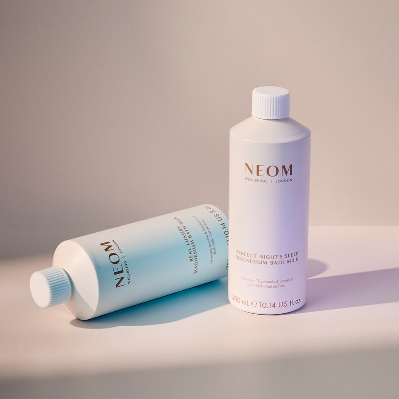 Two NEOM bath products on a neutral background