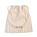Striped beige drawstring bag with NEOM branding on a white background