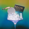 Neom diffuser in a glass with a gradient background