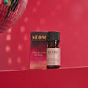 NEOM Christmas Wish Essential Oil Blend bottle and packaging on a red background