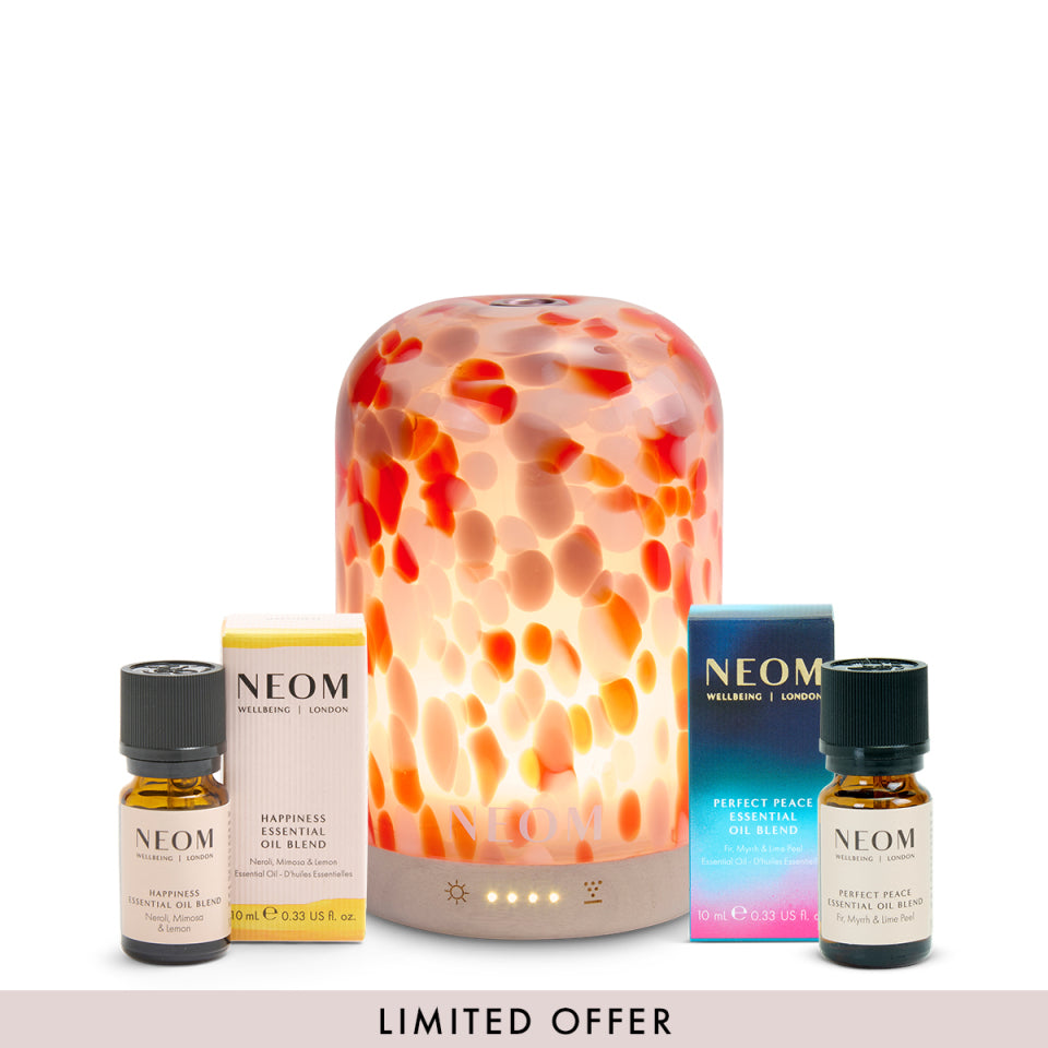 NEOM clementine pod diffuser and happiness essential oil blend and perfect peace essential oil blend with packaging on a white background