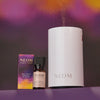 NEOM diffuser, essential oil blend, and essential oil bottle on a purple background