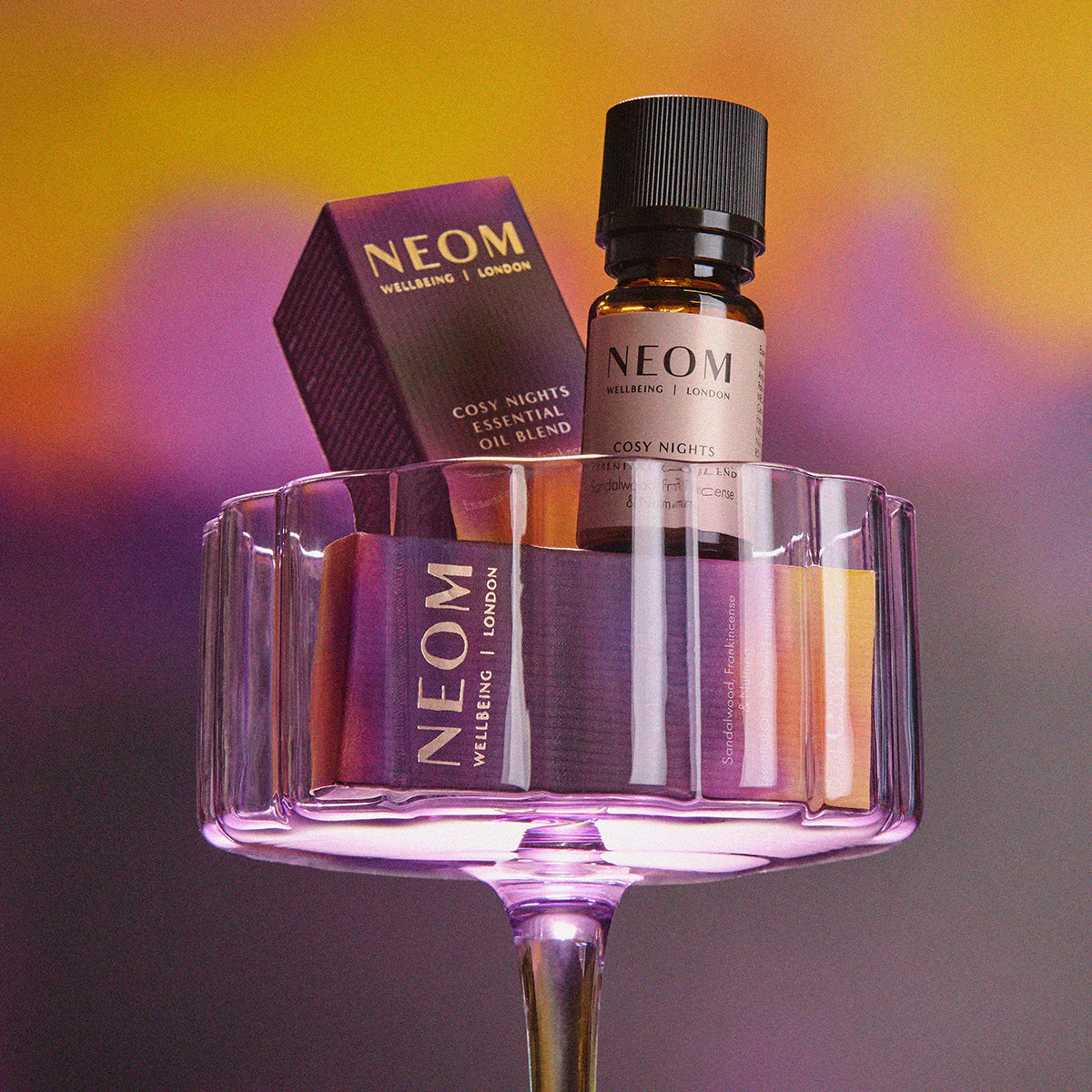 Neom essential oil blend and packaging on a gradient background
