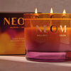 NEOM candle with packaging in the background