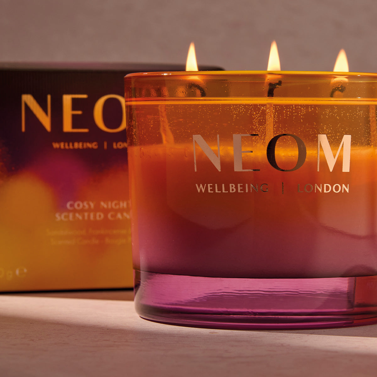 NEOM candle with packaging in the background