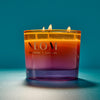 NEOM candle with a gradient colour on a blue background