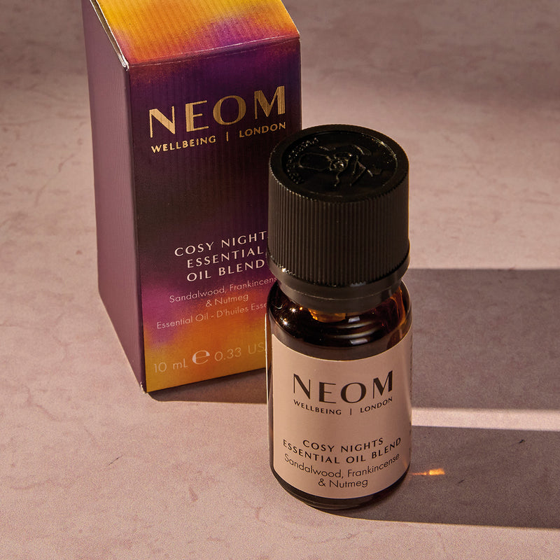 NEOM Cosy Night's essential oil blend bottle and packaging on a neutral background