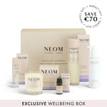 NEOM wellbeing box with various items including candles and bottles on a white background.