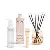 NEOM skincare products including a bottle, tube, and reed diffuser on a white background