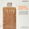 “NEOM Great Day Exfoliating Body Wash bottle with foam beside a sliced citrus fruit. Text reads: ‘Not just a wash, a mood switch! 100% natural fragrances.’ Additional text: ‘Wild mint known to be cooling, invigorating and refreshing. Mandarin to help uplift and boost mood. Olive stone, volcanic perlite and aloe vera gently smooth and soften skin.’”