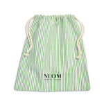 Green and white striped drawstring bag with NEOM branding on a white background