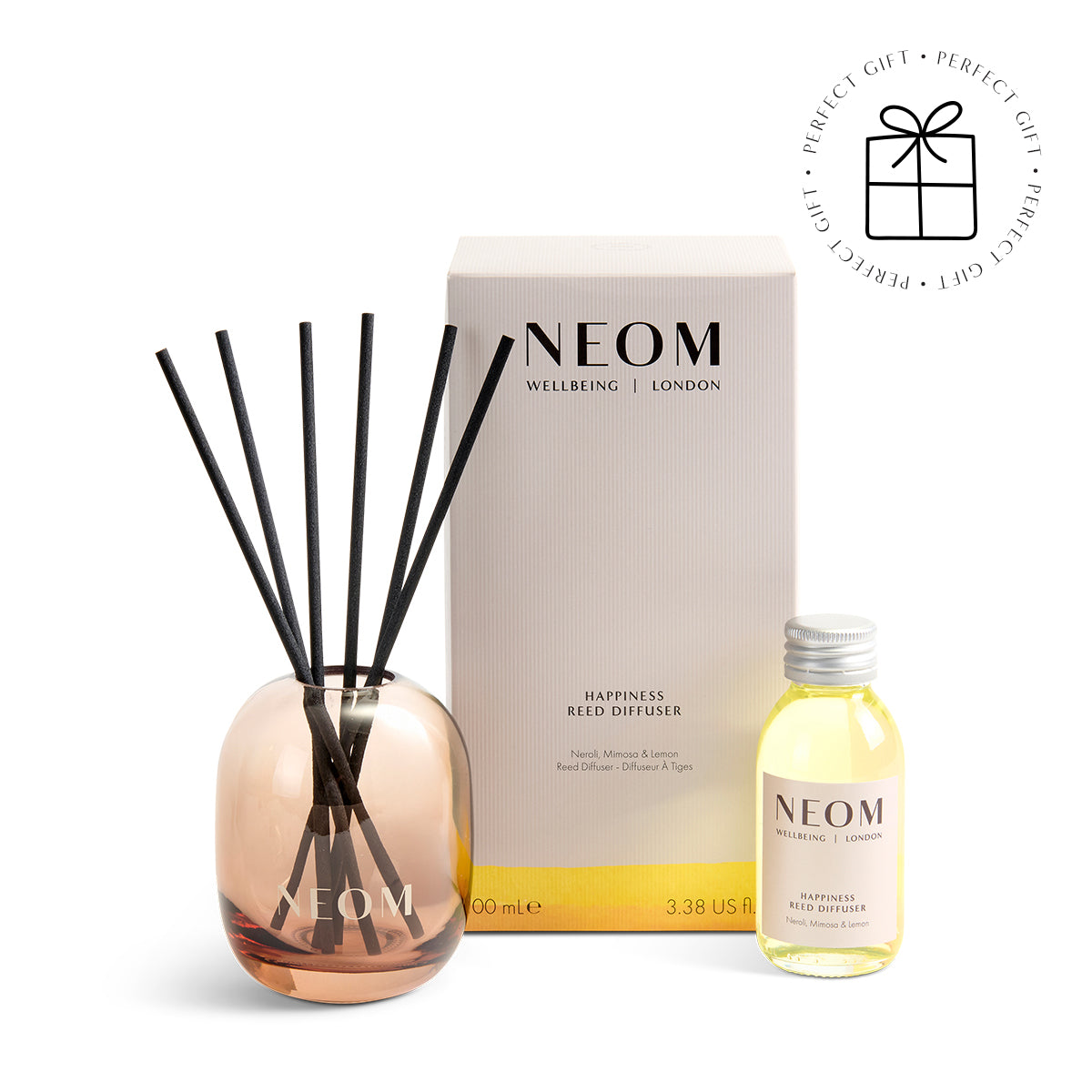 NEOM diffuser set with reeds and bottle on a white background with a Perfect Gift Roundel with a present