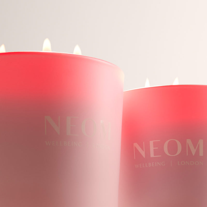 Two NEOM candles with a gradient effect on a light background