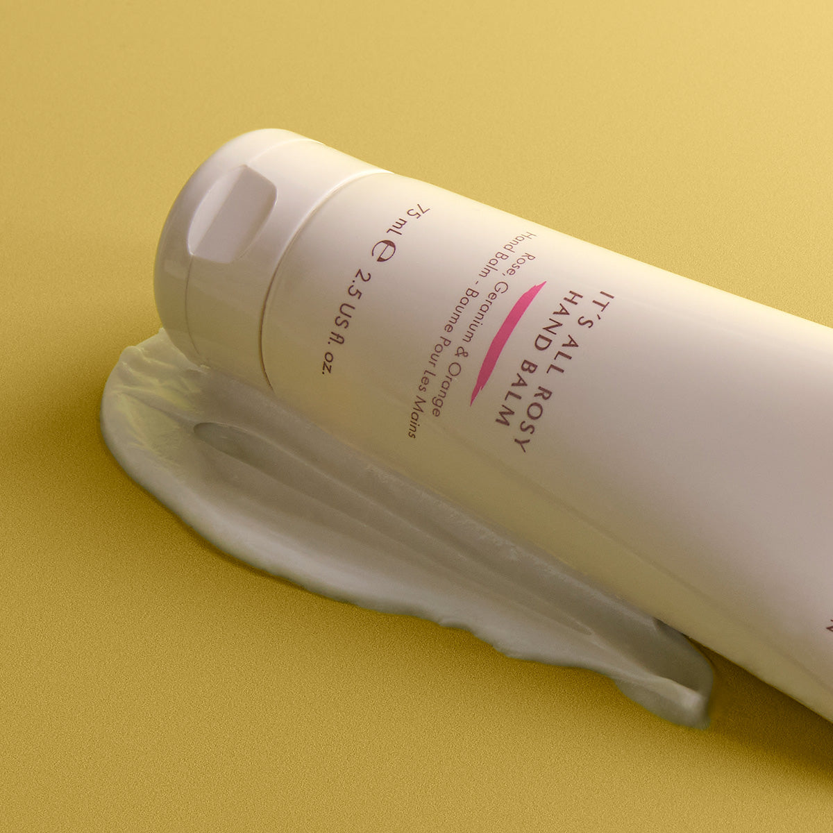 NEOM It's All Rosy Hand Balm on a yellow background