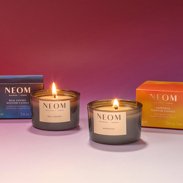 NEOM limited edition real luxury and happiness candles on a pink gradient background