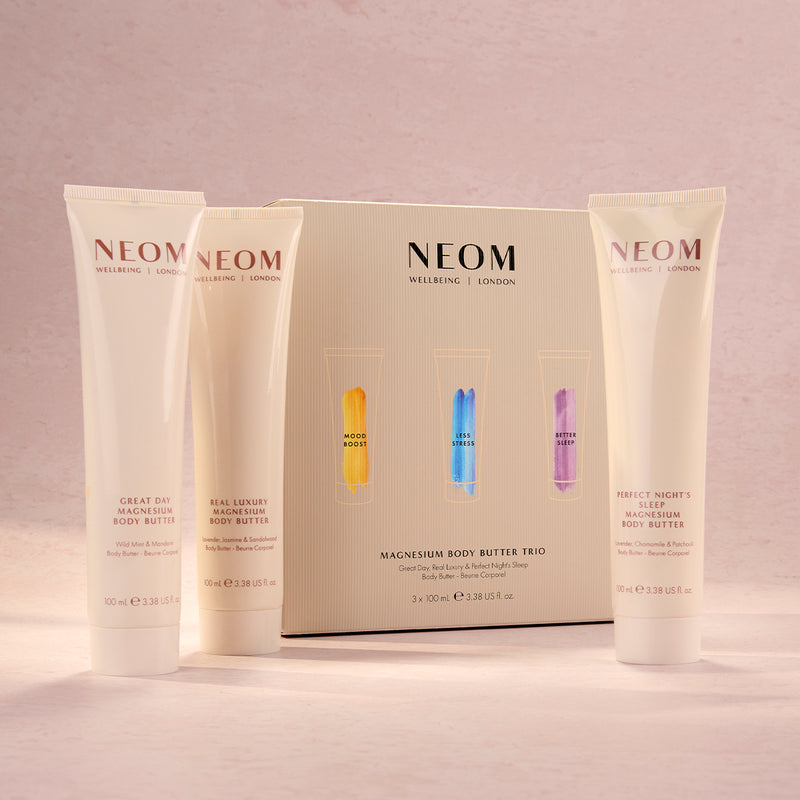 NEOM body butter products on a pink background