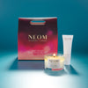 NEOM candle and body butter with packaging on a blue background