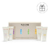 NEOM hand balm product set with four bottles and a box on a white background with a Perfect Gift roundel with a present