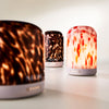 Three NEOM diffusers with tortoiseshell, leopard print diffuser on a light background.