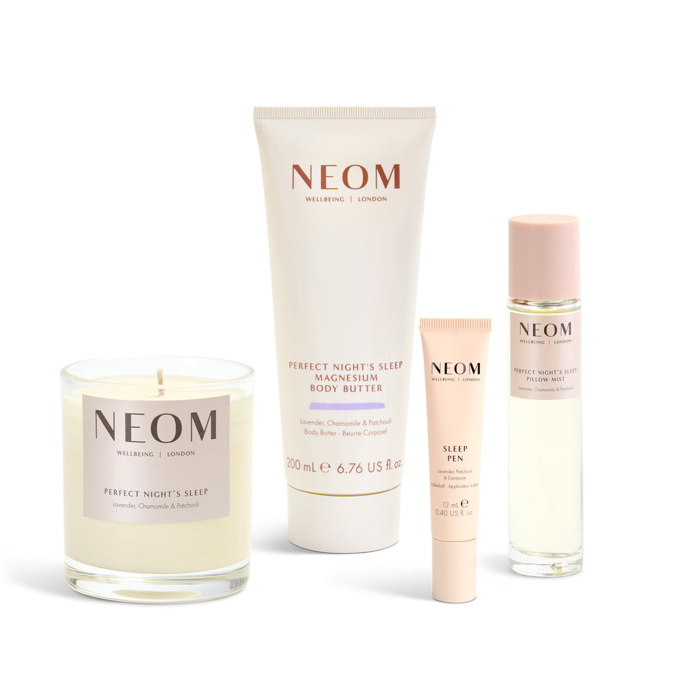 NEOM products including a candle, body butter, sleep pen, and pillow mist on a white background