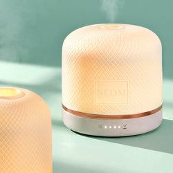 NEOM aromatherapy essential oil diffuser releasing relaxing mist.