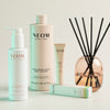 Neom skincare products including a bottle, tube, PEN and diffuser on a light background