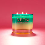 NEOM candle with a gradient design on a pink background