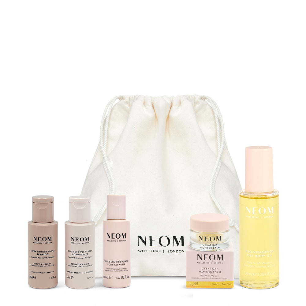 NEOM skincare products with a drawstring bag on a white background