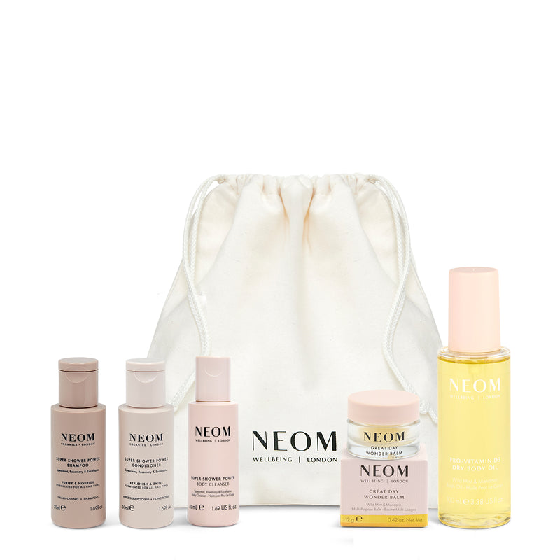 NEOM skincare products with a drawstring bag on a white background