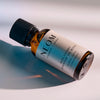 NEOM Real Luxury essential oil blend bottle lying on a surface with soft shadows.