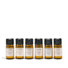 Set of six NEOM essential oil bottles on a white background