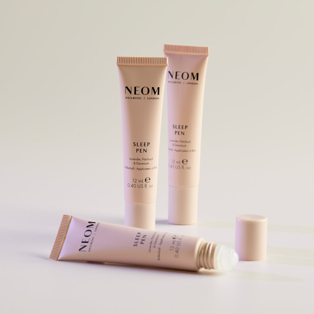 Three NEOM Sleep Pen tubes on a light background