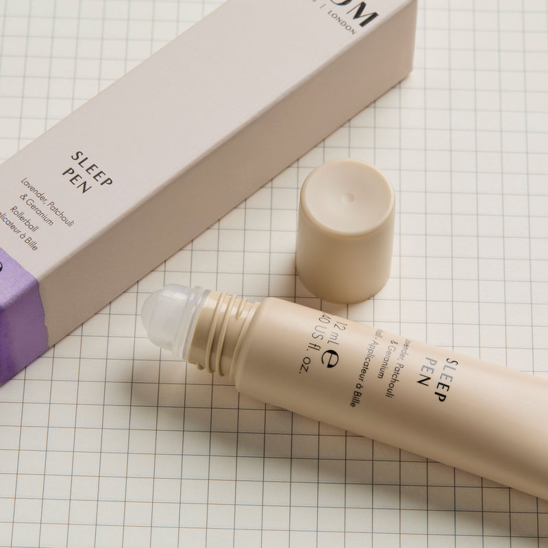 NEOM Sleep Pen product with packaging on a grid background