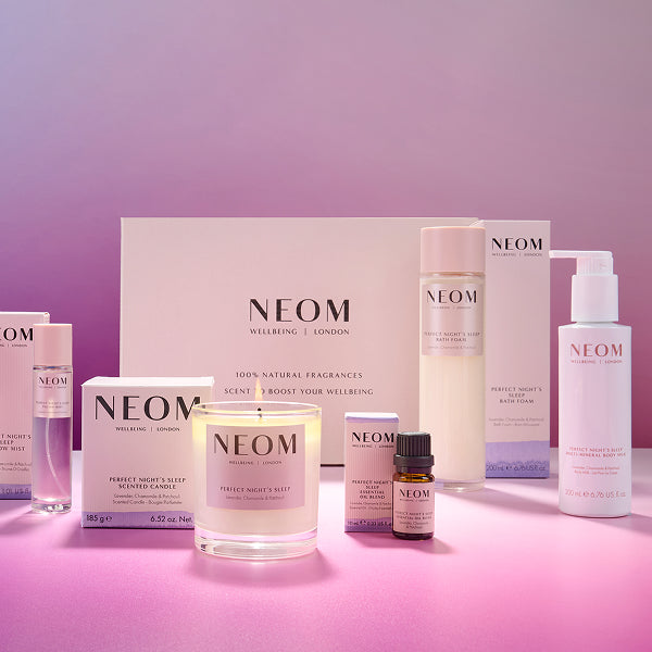 NEOM perfect night's sleep box including skincare and home fragrance products on a pink background 