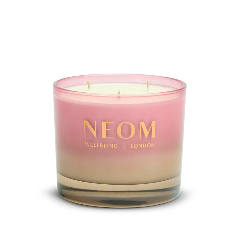 Neom candle with pink and beige gradient on a white background