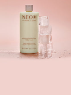 NEOM Super Shower Power body wash with spearmint, eucalyptus and rosemary next to ice cubes for cooling effect