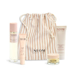 NEOM product set with a striped drawstring bag on a white background
