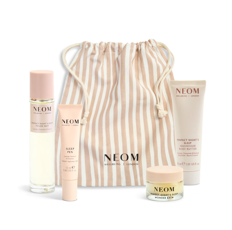 NEOM product set with a striped drawstring bag on a white background