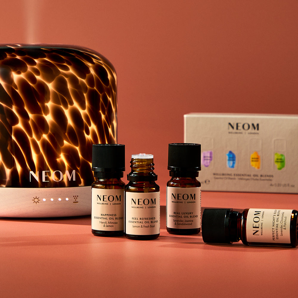 NEOM essential oil and diffuser on a warm-toned background