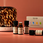 NEOM essential oil and diffuser on a warm-toned background