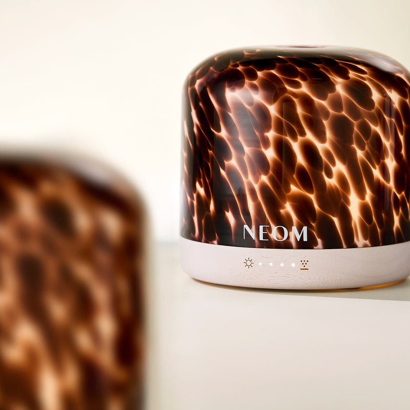NEOM pod luxe electric diffuser with a tortoiseshell pattern on a light background