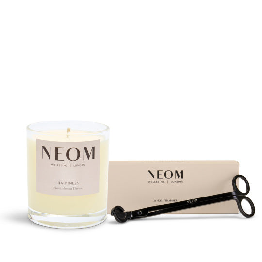 NEOM happiness candle and wick trimmer on a white background