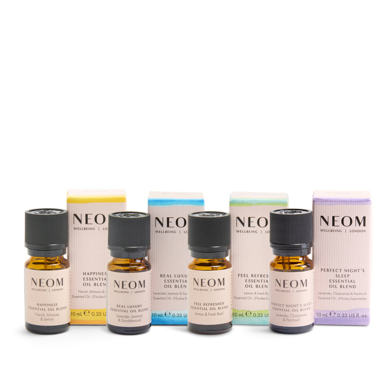Collection of NEOM essential oil bottles and boxes on a white background
