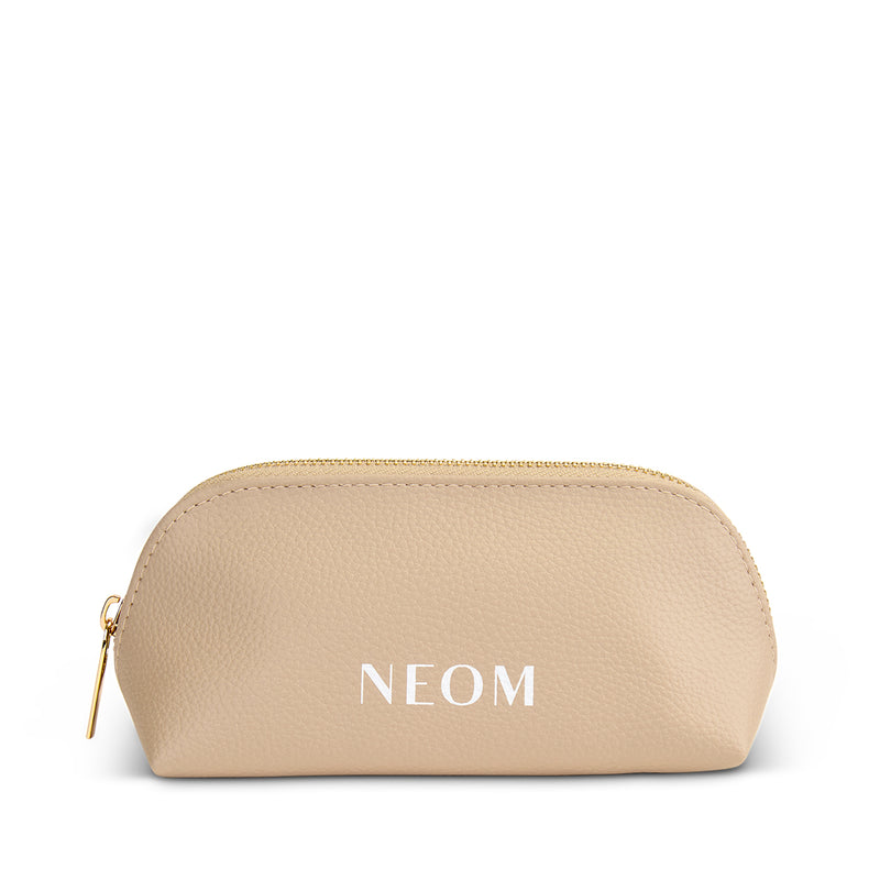 Gold cosmetic bag with 'NEOM' branding on a white background