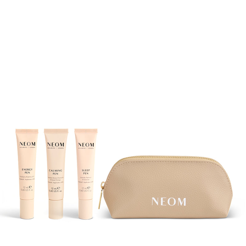 NEOM pens including a gold pouch on a white background