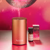 NEOM diffuser, bottle, and box on a reflective surface with pink background